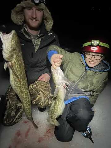 Two people holding Burbot