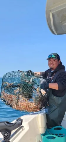 Man holding a pot full of shrimp.
