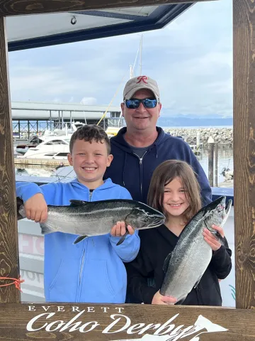 Family holding coho salmon.