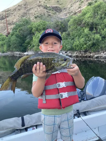 Boy holding smallmouth bass.