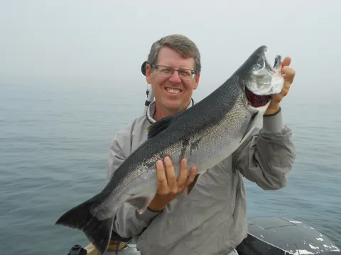Mike Carey holding Coho salmon
